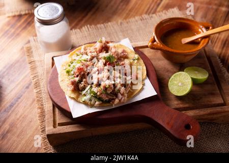 Taco de Carnitas. Tortilla au cornmeal avec porc frite. Apéritif mexicain traditionnel généralement accompagné de coriandre, d'oignon et de sauce chaude. Banque D'Images