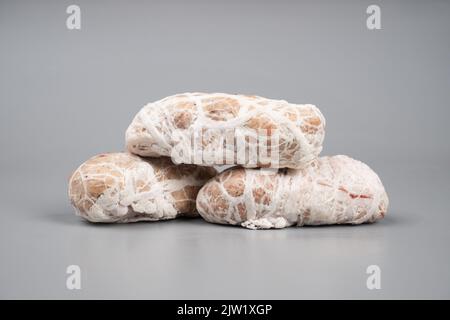 boulettes de viande de porc crues dans l'intestin de porc sur fond gris. Banque D'Images