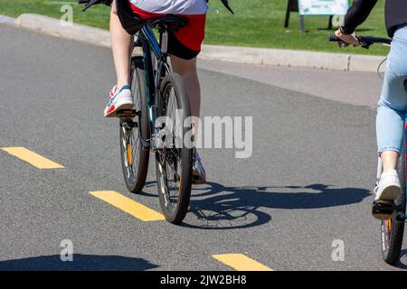 Cycliste sur une piste cyclable dans le parc. Passage en vélo dans l'air frais. Vélo par jour ensoleillé Banque D'Images