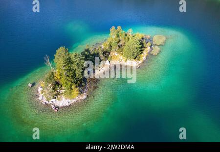 Vue aérienne d'une petite île avec des arbres dans l'eau bleu-vert du lac, lac Eibsee, Bavière, Allemagne Banque D'Images