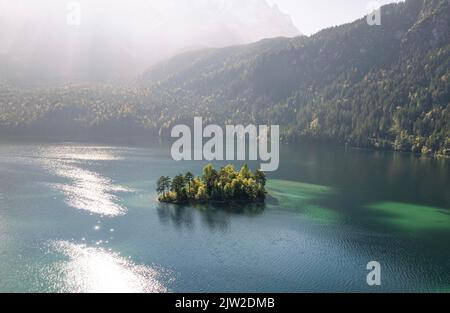 Vue aérienne d'une petite île boisée sur le lac en plein soleil, lac Eibsee, Bavière, Allemagne Banque D'Images