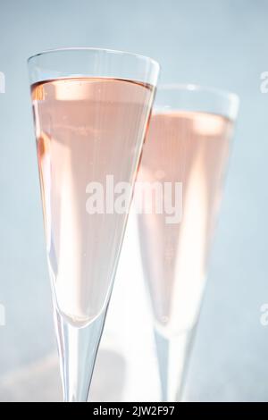 Vin mousseux rose ou champagne dans des verres en cristal sur fond clair par temps ensoleillé Banque D'Images
