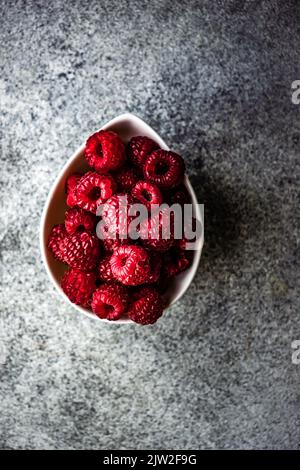 De dessus, gros plan des framboises mûres dans le bol Banque D'Images
