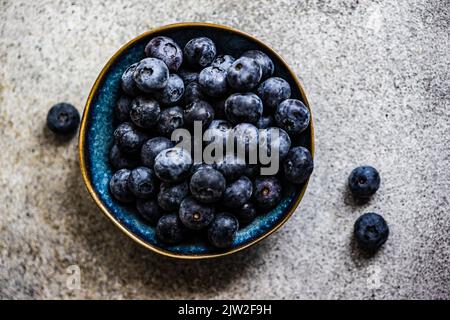 Des bleuets mûrs au-dessus dans le bol comme un concept alimentaire sain Banque D'Images