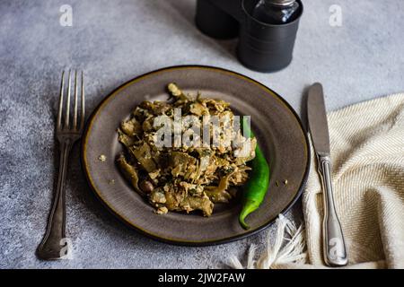 Plat traditionnel de lobio d'été géorgien avec haricots français avec œufs et herbes sur fond de pierre avec espace de copie Banque D'Images