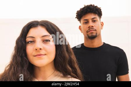 Vue avant du couple multiracial regardant la caméra Banque D'Images