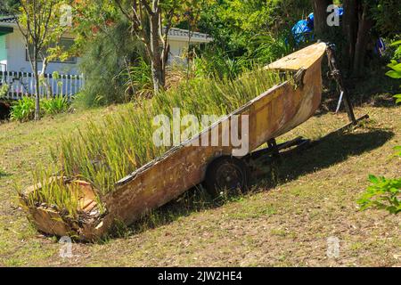 Un vieux bateau en ruines, qui a été rempli de fougères et transformé en un planteur dans un jardin Banque D'Images