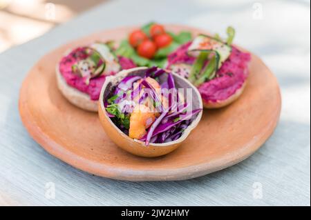 Salade de légumes frais à base de carottes de chou violet et d'herbes servies dans un bol sur l'assiette avec des sandwiches végétariens pour le déjeuner Banque D'Images