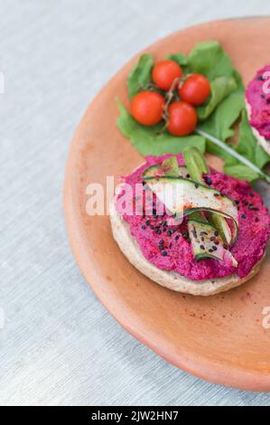 Salade de légumes frais à base de carottes de chou violet et d'herbes servies dans un bol sur l'assiette avec des sandwiches végétariens pour le déjeuner Banque D'Images