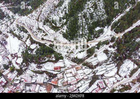 Vue panoramique aérienne de l'étroite route asphaltée près de la pittoresque vallée montagneuse couverte de neige à Rascafria Banque D'Images