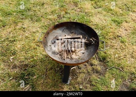 Une fosse à feu avec du bois et un peu de bois prêt à être allumé sur une ferme Banque D'Images