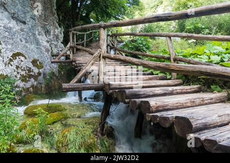 Un pont en bois au-dessus d'une cascade dans le parc national des lacs de Plitvice, Croatie, Europe. Banque D'Images