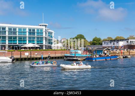 Personnes prenant des excursions en bateau sur la rivière Stour en passant devant le Captain's Club Hotel & Spa à Christchurch, Dorset, Angleterre, Royaume-Uni Banque D'Images