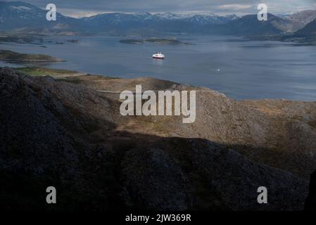 Hurtigrluten navire Kong Harald passant le dôme de granit de Torghatten dans le centre de la Norvège tout en quittant Brønnøysund. Banque D'Images