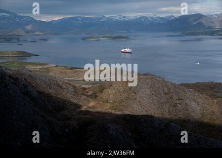 Hurtigrluten navire Kong Harald passant le dôme de granit de Torghatten dans le centre de la Norvège tout en quittant Brønnøysund. Banque D'Images