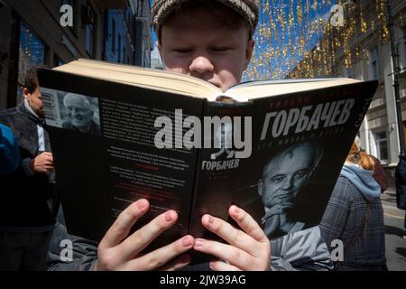 Moscou, Russie. 3rd septembre 2022. Un jeune homme lit un livre de William Taubman intitulé « Gorbatchev: Sa vie et ses temps » devant la salle des colonnes de la Chambre des syndicats, où se tient un service commémoratif pour Mikhaïl Gorbatchev à Moscou, en Russie. Nikolay Vinokurov/Alay Live News Banque D'Images