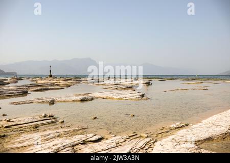 Jamaïque Beach pendant la journée d'été à Sirmione. Italian Rocky Beach à Lago di Garda. Belle scène du lac en Italie. Banque D'Images