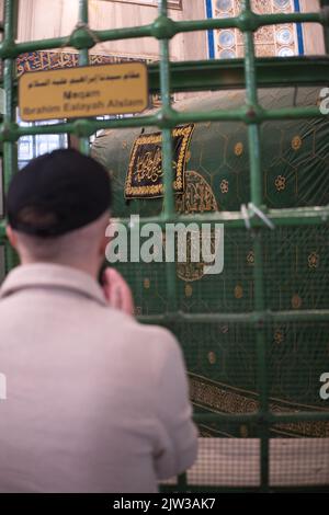 Une personne religieuse musulmane dit la prière près de la tombe dans la mosquée Banque D'Images