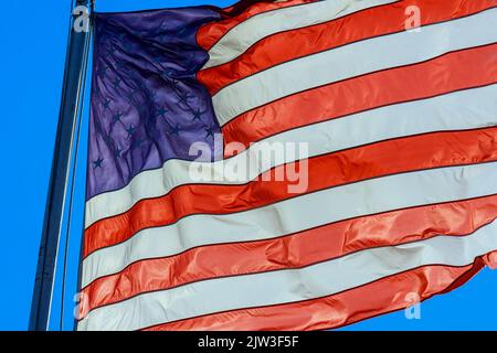 Le drapeau américain qui agite sur un mât est un signe de patriotisme Banque D'Images