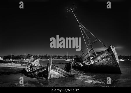 Un cliché noir et blanc des ruines d'un vieux bateau sur l'eau Banque D'Images