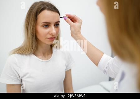 Médecin neurologue examinant la patiente. Contrôler les réflexes du corps humain avec une brosse Banque D'Images