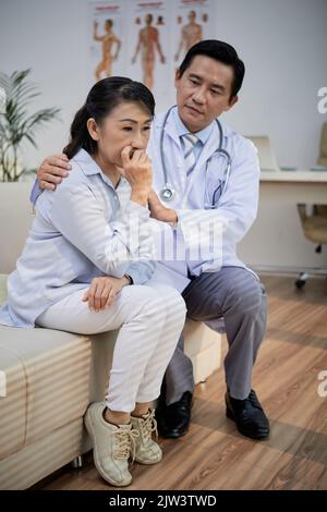 Médecin rassurant patient âgé triste avec un diagnostic dangereux Banque D'Images