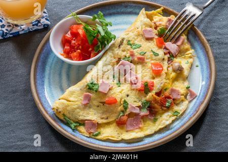 Omelette aux œufs avec jambon, champignons et tomates Banque D'Images