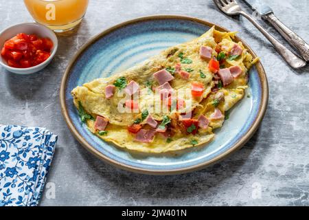 Omelette aux œufs avec jambon, champignons et tomates Banque D'Images