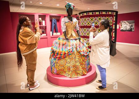 Londres, Royaume-Uni. 03rd septembre 2022. Deux visiteurs prennent des photos de la belle robe. Une robe « d'art portable » de Karen Arthur, artiste basée à Catford, explore l'entité noire féminine. Le Musée a ouvert ses portes en 2020 pendant la pandémie et explore la façon dont le mouvement des personnes en provenance et à destination du Royaume-Uni a façonné les communautés et la nation. Credit: Imagetraceur/Alamy Live News Banque D'Images