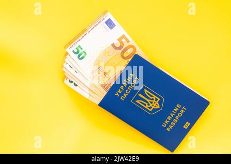 passeports ukrainiens et billets de 50 euros sur fond jaune Banque D'Images