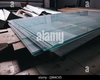 Vitrage d'un nouveau bureau, isolation des cadres de fenêtres. Une pile de feuilles de verre sur un chantier de construction, le matériau est le verre pour le vitrage du bâtiment A. Banque D'Images