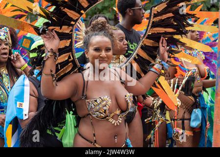 Londres, Angleterre, Royaume-Uni - 29 août 2022: Jeune fille vêtue pour le carnaval avec des plumes dans la rue, à Notting Hill Gate Banque D'Images