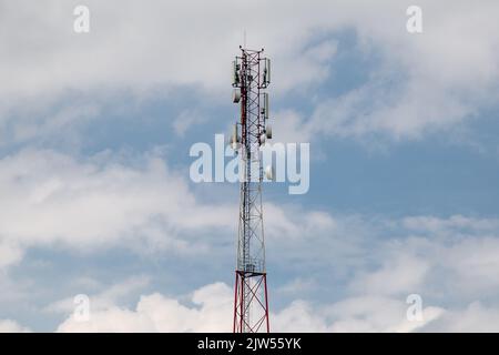 Télécommunications. Tour cellulaire sur fond bleu ciel. Banque D'Images