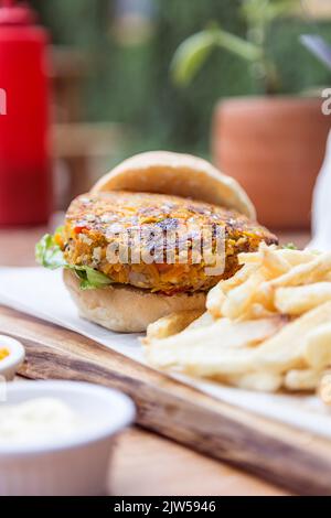 Hamburger végétalien, avec carottes, lentilles, poivrons et oignons, servi avec des frites. Restaurant végétalien. Banque D'Images