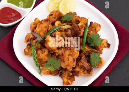 Beignets indiens favoris pour le thé le chou-fleur Pakoda également appelé Gobi Papora est fait de fleurs fraîches de Brassica oleracea mélangées à la farine de Gram Bengale Banque D'Images