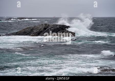 Une image de fortes vagues qui frappent un grand rocher sur la côte de la mer de Norvège Banque D'Images