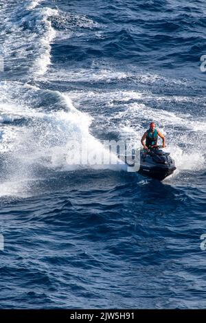 Un jeune homme qui fait du scooter des mers dans la mer Méditerranée à Ibiza en Espagne Banque D'Images