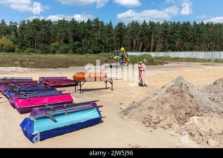 Bucha, Ukraine. 2nd septembre 2022. Un prêtre lit une prière et exécute une cérémonie funéraire pour les victimes innocentes de l'agression russe au cimetière de Bucha. Des rangées de cercueils avec des croix et le nombre de victimes non identifiées sont illustrés. Coffins contenant les corps de personnes non identifiées tuées dans le district de Bucha au moment de l'occupation russe, lors d'une cérémonie d'enterrement dans un cimetière de Bucha, dans la région de Kiev, en Ukraine. Des mois après le retrait des forces russes du district de Bucha, les corps qui n'ont pas été identifiés ont été enterrés et marqués de numéros dans un cimetière Banque D'Images