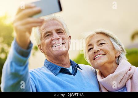 Des souvenirs inoubliables. Un couple senior prend une photo ensemble dans un parc. Banque D'Images