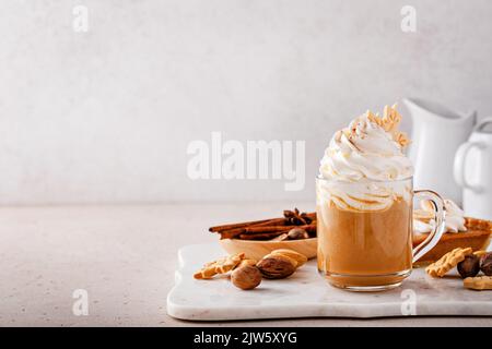 Latte aux épices à la citrouille recouverte de crème fouettée et de cannelle Banque D'Images