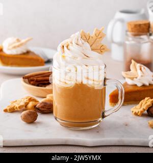 Latte aux épices à la citrouille recouverte de crème fouettée et de cannelle Banque D'Images