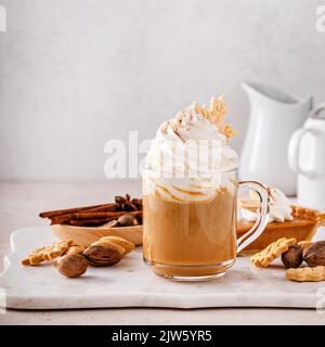 Latte aux épices à la citrouille recouverte de crème fouettée et de cannelle Banque D'Images