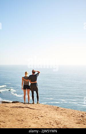 Il n'y a pas de raccourcis vers un endroit qui vaut la peine d'y aller. Un jeune couple regarde la vue depuis le sommet d'une montagne. Banque D'Images