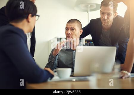 La communication est essentielle au succès de toute équipe. Un groupe de collègues ayant une discussion dans une salle de réunion. Banque D'Images