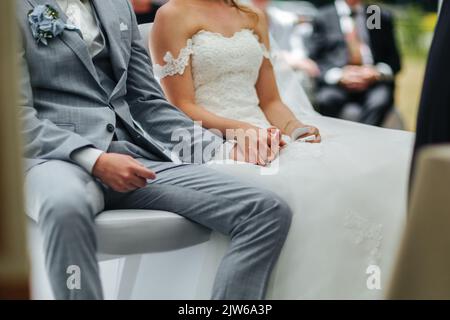 Mariée et marié tenant la main pendant leur cérémonie de mariage Banque D'Images