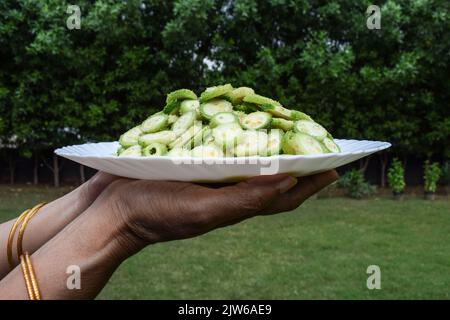 La plaque de conservation femelle de légumes de gourde épineux également connu sous le nom de gourdes de colonne ou Kantola sont des légumes sains saisonniers cultivés en Inde Asie, coupé dans sli Banque D'Images