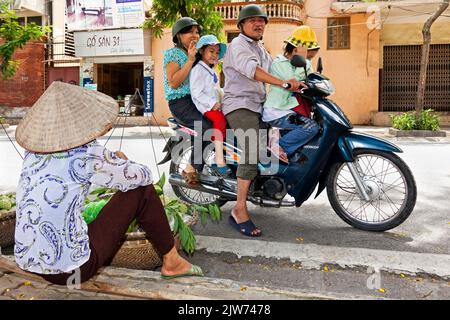 Quatre membres de la famille vietnamienne à moto, Hai Phong, Vietnam Banque D'Images