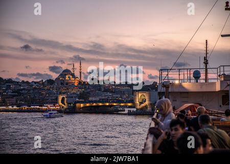 Istanbul, Turquie. 03rd septembre 2022. Les gens vus assis sur la terrasse des lignes de la ville ferry au coucher du soleil à Istanbul et le pont de Galata en arrière-plan avec les nuages ont créé une vue magnifique. Crédit : SOPA Images Limited/Alamy Live News Banque D'Images