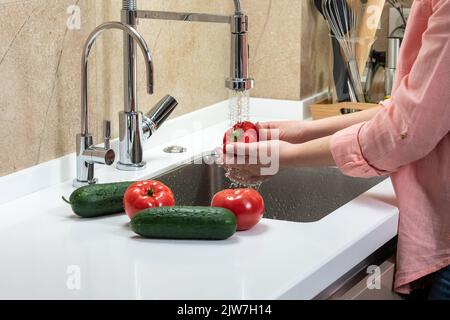 Les mains de la femme se lavent au poivre sous l'eau courante Banque D'Images