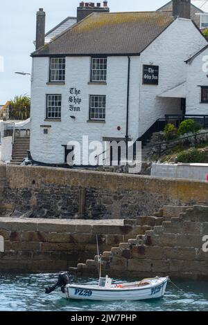 Le Ship Inn Pub Porthleven, avec un petit bateau de pêche amarré en dessous. Banque D'Images